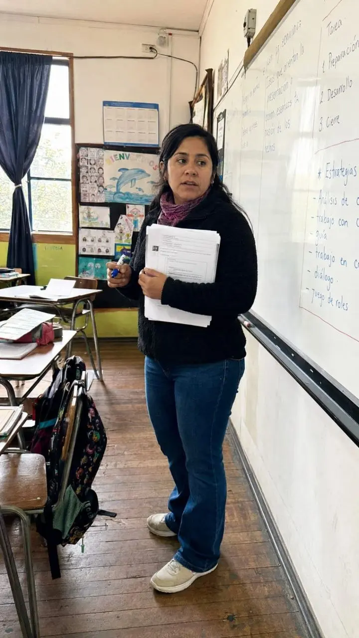 Docente chilena preparando una actividad frente a la pizarra